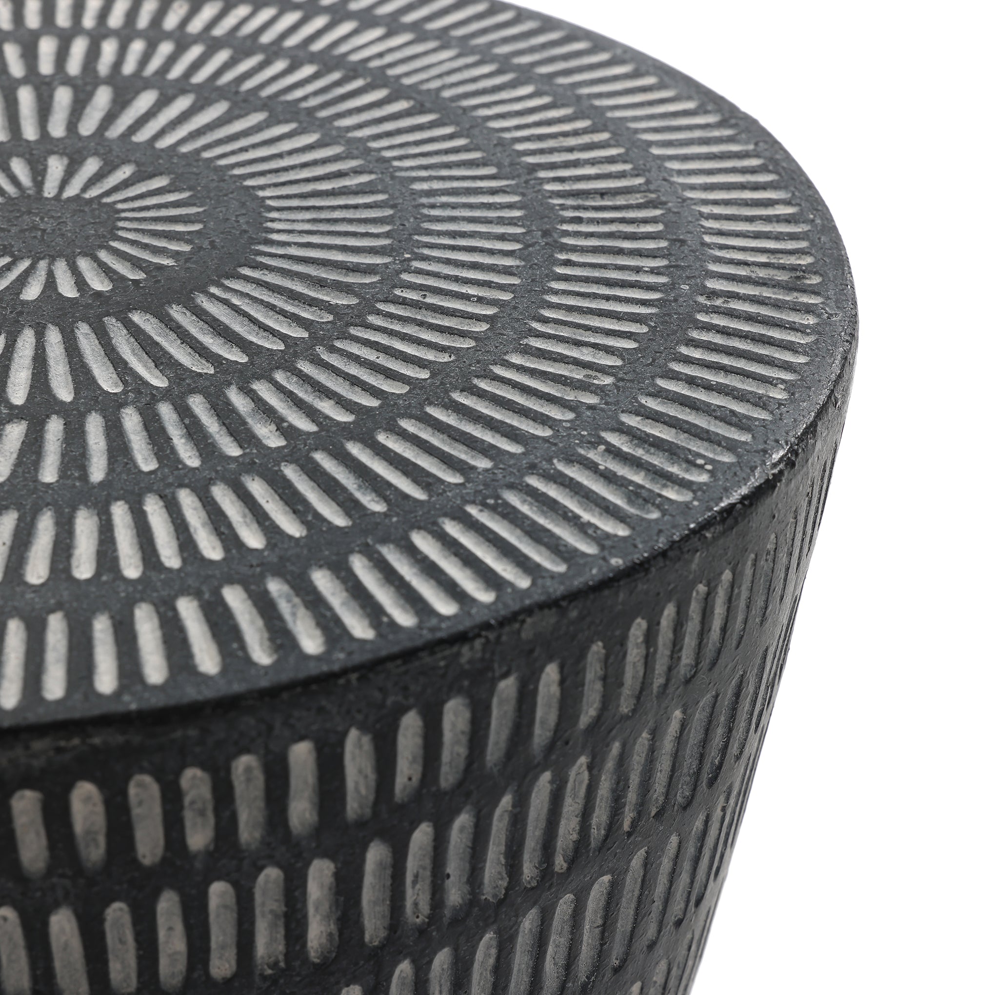 The LuxenHome Meru outdoor end/side table features a round, textured surface with concentric patterns. Crafted from durable magnesium oxide, its geometric optical illusion effect combines alternating light and dark lines with a modern black finish.