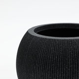 Close-up of a black, textured, round indoor outdoor planter with a wide opening, crafted from durable polyethylene against a white background.