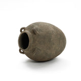 The LuxenHome Rustic brown terracotta cauldron vase features a 15.4-inch height, a wide opening, and dual small handles. Its rough surface against a plain white backdrop exudes natural elegance and an aged charm reminiscent of simpler times.