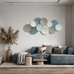 A modern living room features a blue sectional sofa adorned with beige and gray cushions, complemented by a wooden coffee table. Pampas grass in a vase adds a natural touch, while abstract wall art provides an artistic flair above the sofa.