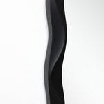 Close-up of highlighting the modern wall mirror’s curved design and clear reflection.