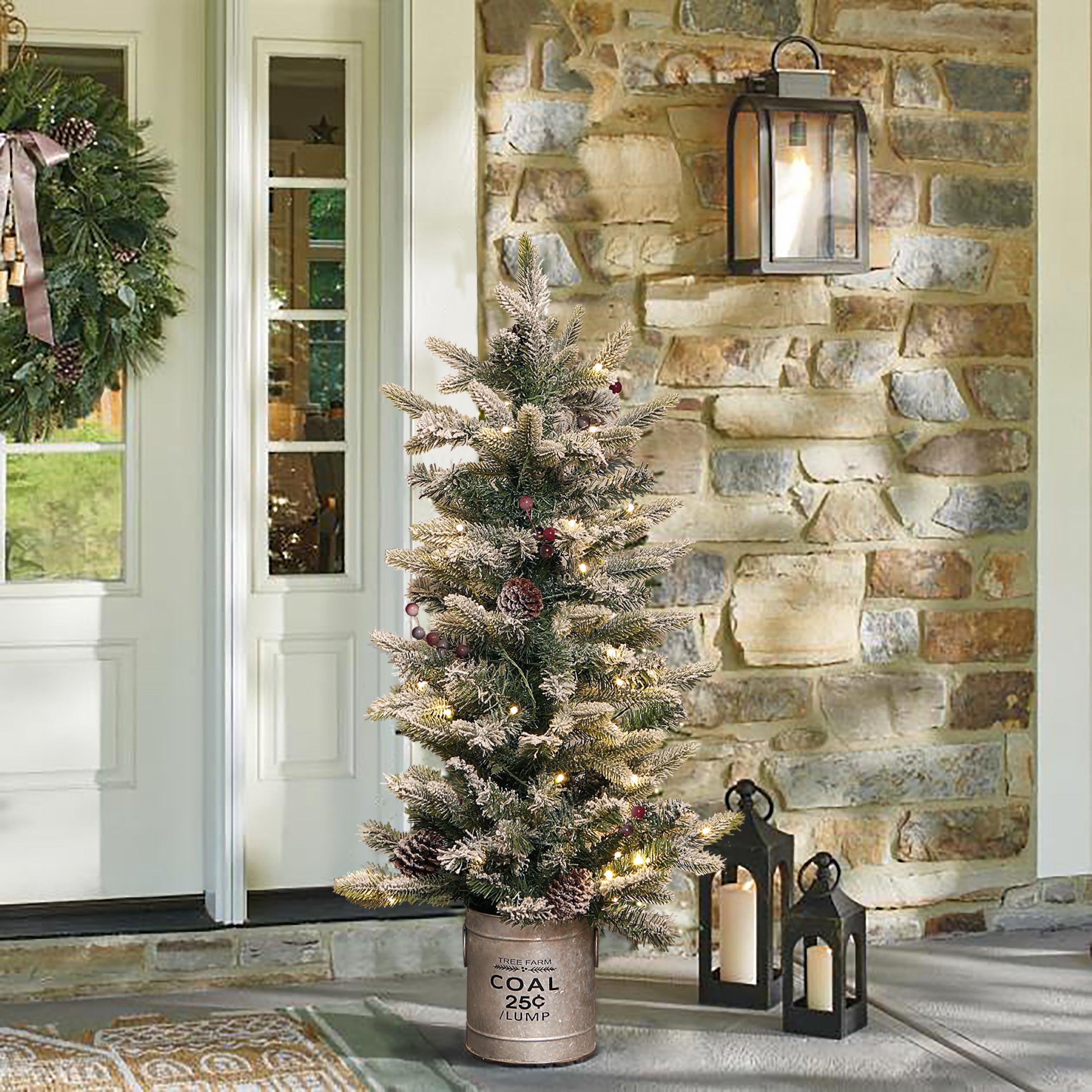 snow-flocked-potted-pre-lit-christmas-tree-stand-at-the-porch