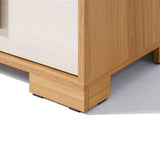 Close-up of the corner of a wooden nightstand on a white surface, showcasing its square base and light wood grain texture, highlighting its wooden finish.