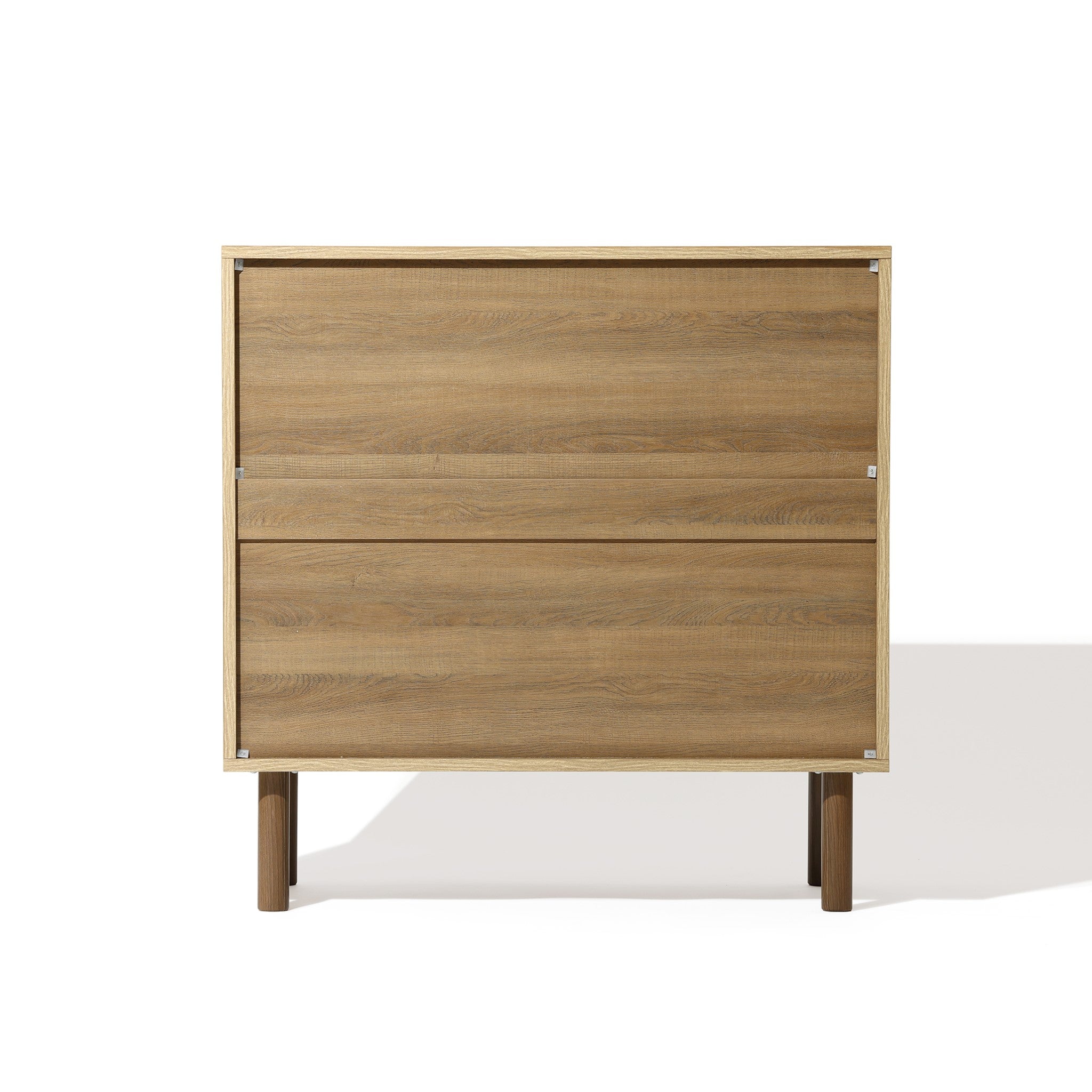 A wooden cabinet with jute-woven doors and two drawers on short legs exudes natural modernism, set against a white background. This versatile storage solution seamlessly blends style and function.