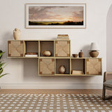 A modern living room features a wall-mounted storage cabinet with a woven rope facade, elegantly complementing decorative items and a sunset landscape painting above. The patterned rug and potted plant provide mid-century modern accents.