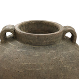 Close-up of LuxenHomes Rustic Brown Terracotta Cauldron Vase, 14.6 h. With its wide opening and two round handles, it exudes natural elegance through a rough texture and earthy tones, boasting age-old imperfections that add charm to any home decor.