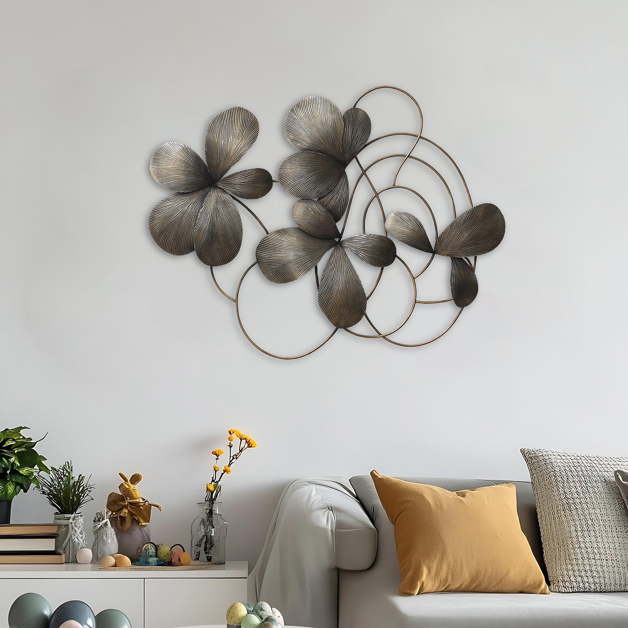 Floral metal wall art with overlapping flower and circle shapes hangs above a light gray sofa.