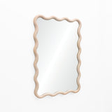 A decorative wall mirror with a wavy natural wooden frame and pine wood finish elegantly hangs on a plain white wall.