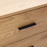 Buffet cabinet sideboard, close-up of two wooden drawers with black metal handles, highlighting the oak wood grain texture and clean mid century design.