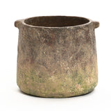 A rustic, cylindrical clay pot with two small handles, displaying a weathered, earthy texture and a slightly uneven rim, reminiscent of a ginger root brown vase.