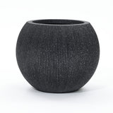 A round, textured black modern planter with a wide opening is set against a plain white background. Ideal for both indoor and outdoor spaces, this piece is crafted from durable polyethylene to withstand the elements while maintaining its sleek style.