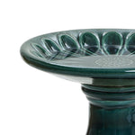 Green ceramic birdbath with a fluted bowl and a floral pattern in the center, perfect for enhancing your outdoor space. It features a sturdy pedestal base.