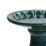 Green ceramic birdbath with a fluted bowl and a floral pattern in the center, perfect for enhancing your outdoor space. It features a sturdy pedestal base.