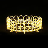 Circular, decor fence with scroll pattern by bright yellow led fence lights against black background.