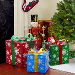 LED gift boxes wrapped in festive paper with bows sit near a decorated Christmas tree and a nutcracker figurine.