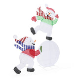 2 pre-lit snowmen with scarves, hats ,playfully interacting, with one standing on snowball, the other pushing.