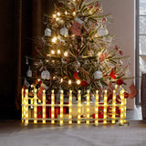 Close-up of white plastic fence segment with decor swirl design,flat base, displayed on a gray surface.