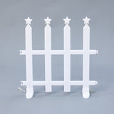 White plastic picket fence with 4 vertical posts, each topped with 5 pointed star, against plain gray background.