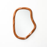 Asymmetrical wall mirror with a wooden wavy-edged frame, perfect as a striking to elevate modern home décor.