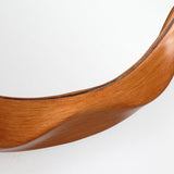 Close-up of a curved wooden frame against a white background, showing smooth grain and polished finish.
