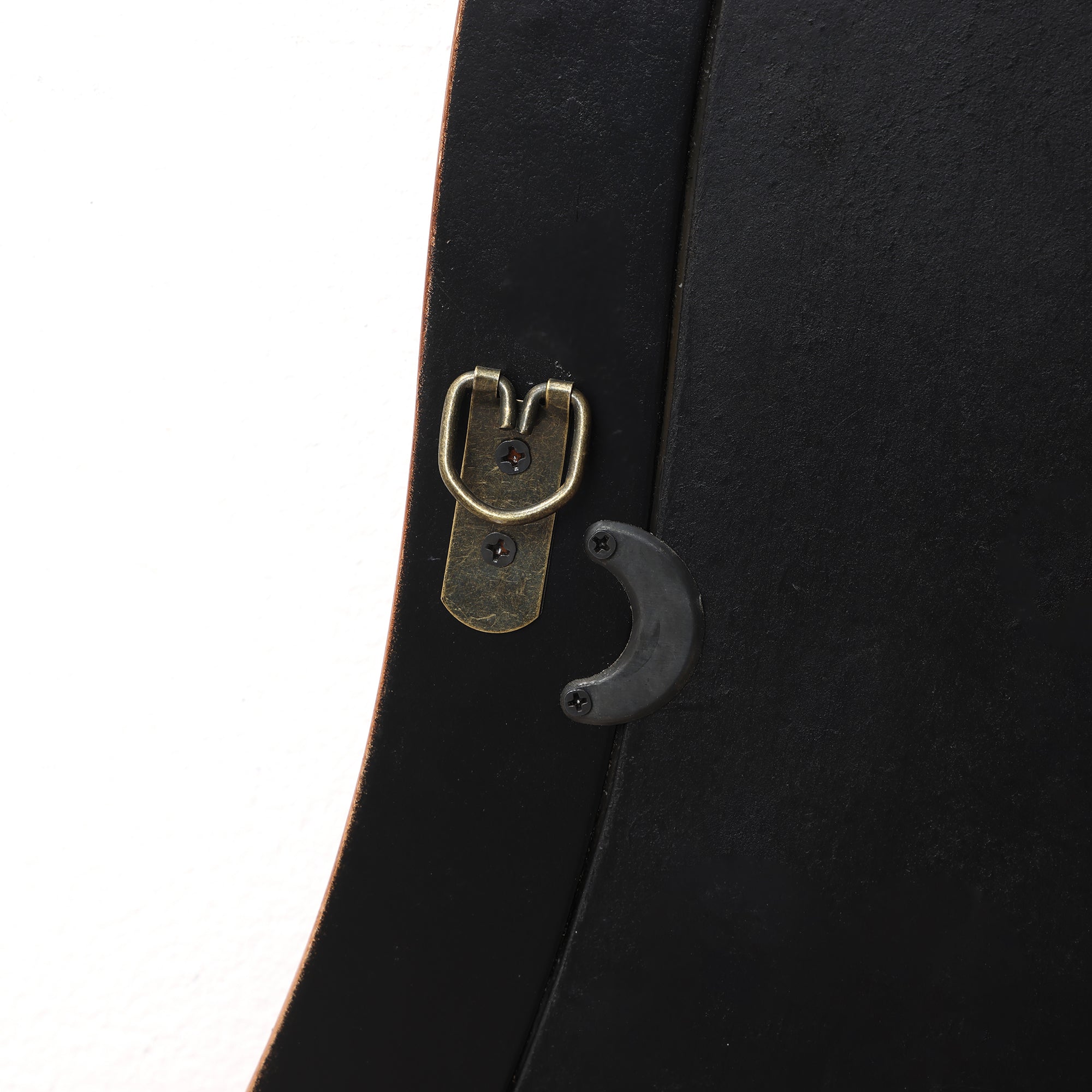 Wood frame wall mirror highlighting a brass hanging hook and black plastic support attached with screws.