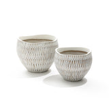 The set includes two LuxenHome white textured resin round planters, the larger one being taller. These planters feature intricate geometric designs and resemble elegant ceramic vases, casting soft shadows on a plain white background.