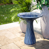 Blue ceramic birdbath with leaves and swirl pattern