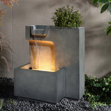 Modern outdoor relaxation fountain with water cascading over a lit panel, enhanced by LED lighting. Surrounded by lush greenery and smooth pebbles, this minimalist design creates a serene escape in your garden.