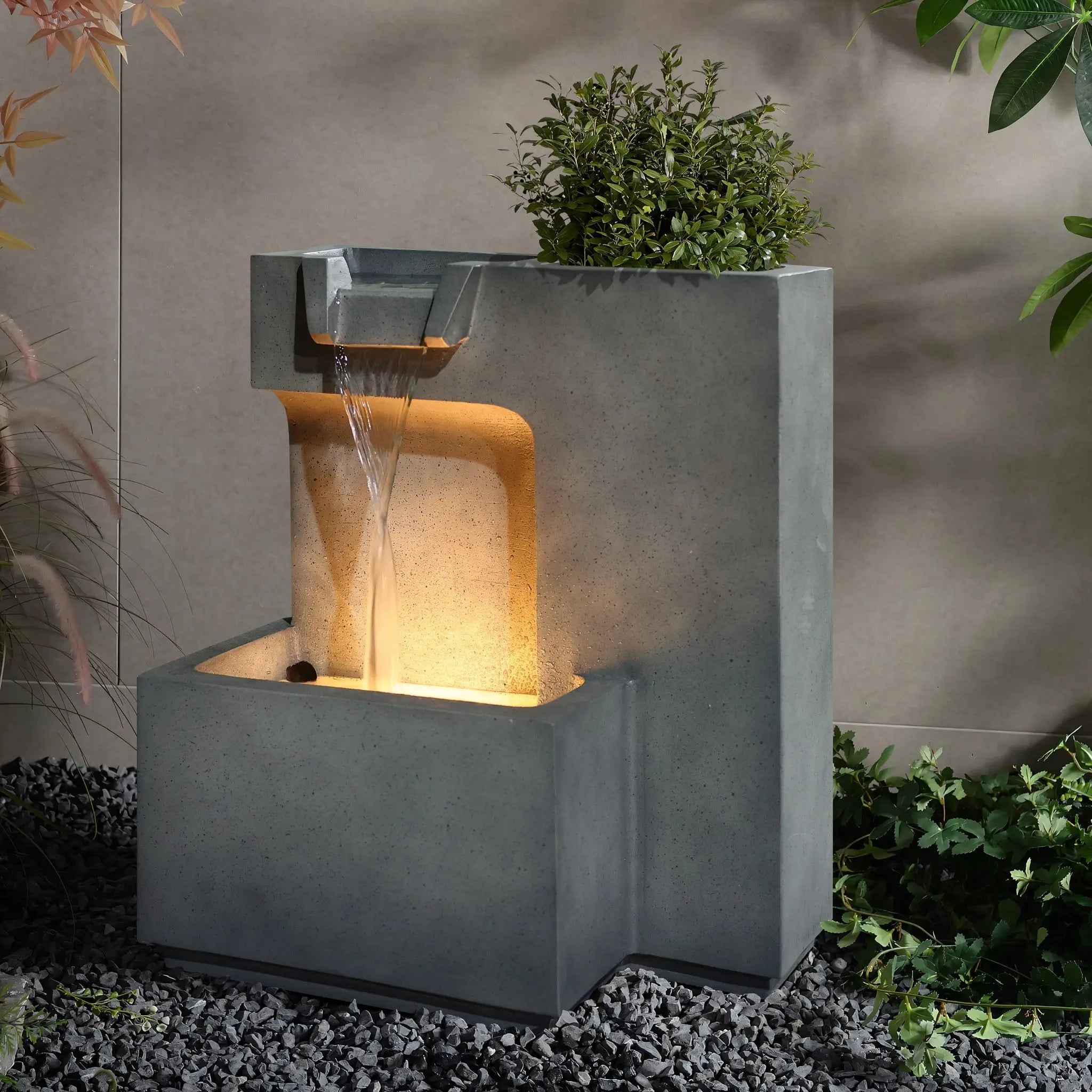 modern outdoor water fountain with lights and planter feature