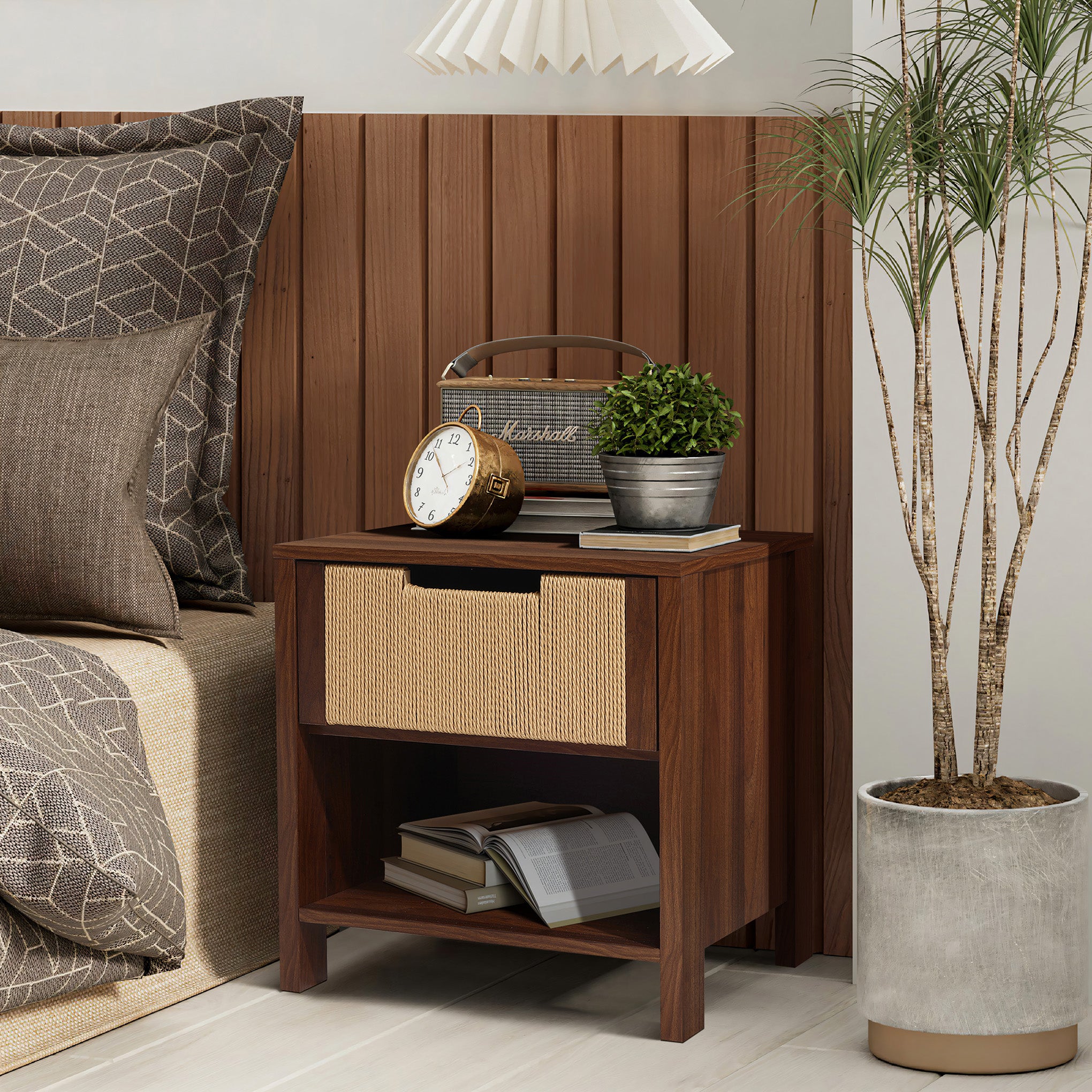 A end table nightstand with a woven drawer, books on the shelf, an alarm clock, a potted plant, and a vintage radio.