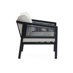 Side view of a modern black outdoor armchair from a set, featuring PE rattan construction with waterproof light gray cushions and a sleek slatted back.