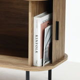 The LuxenHome Aria TV stand with an oak finish presents a mid-century modern style. Two magazines, Kinfolk and You Are My Dream, rest upright against the minimalist back panel, adding to its sleek design.