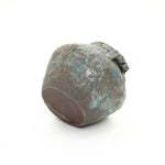 Weathered round handcrafted vase with a blue and brown textured surface, shown against a white background.