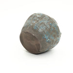 Weathered round-bottomed handcrafted pottery vessel with a mottled brown and blue surface.