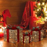 3 gift boxes with lights ,red ribbons sit by christmas tree ,presents, near red rocking horse ,lantern on wooden floor.