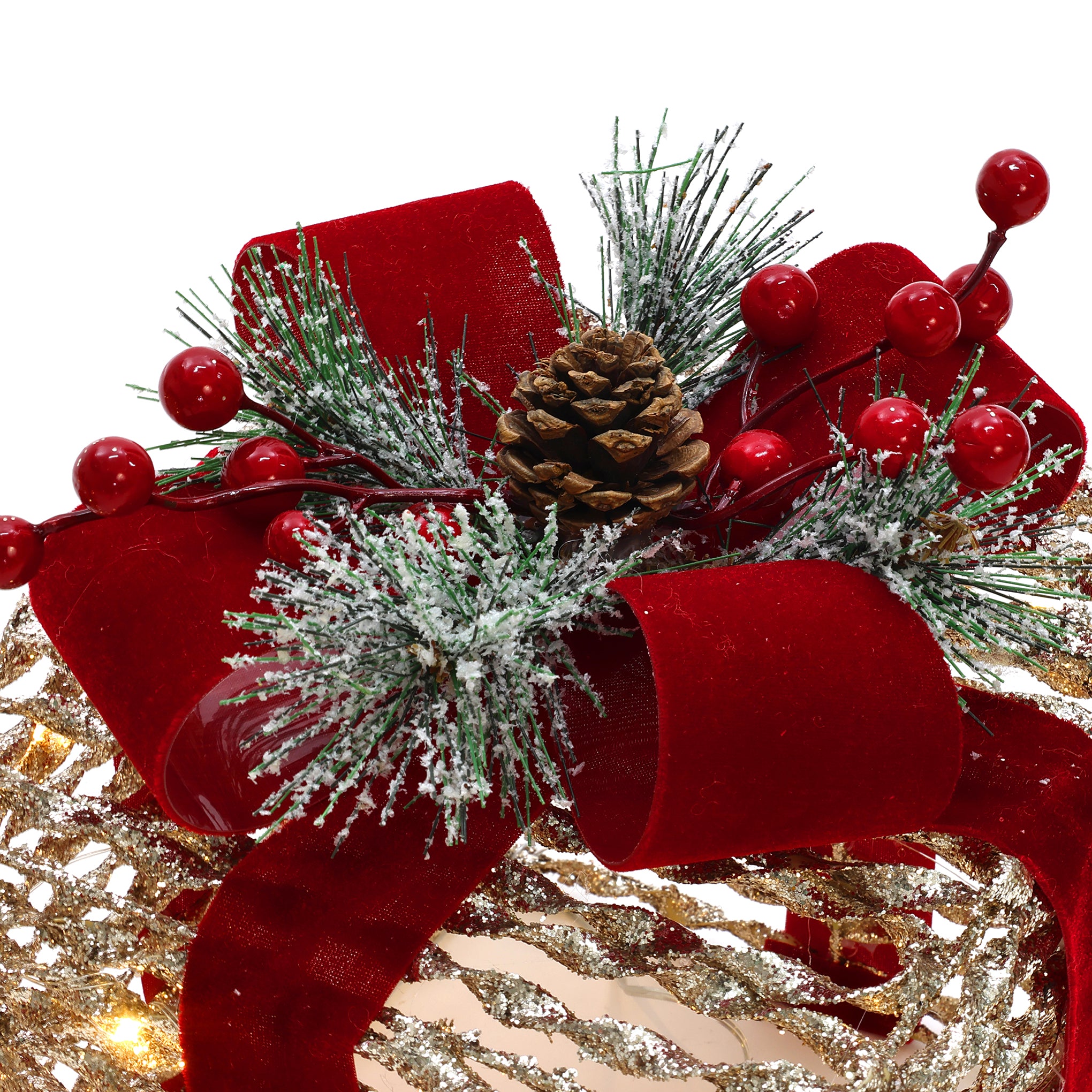 Decor arrangement featuring red bow, pine branches with white frost, red berries, pinecone on gold background.
