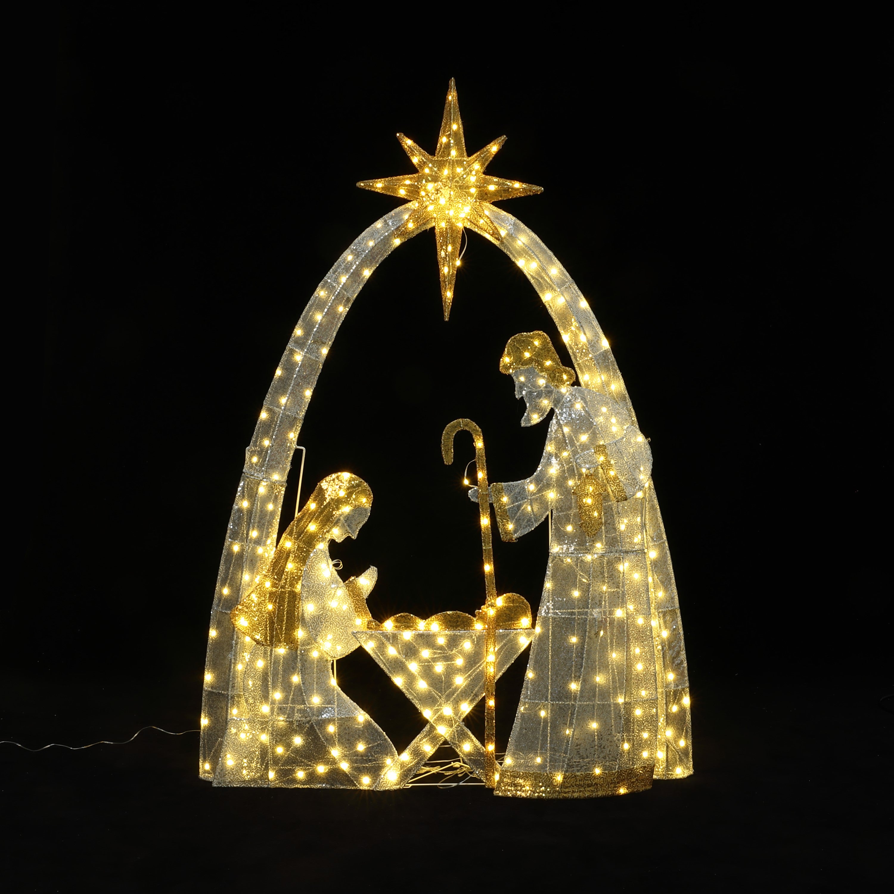 Pre-lit outdoor holiday decor nativity scene with Mary, Joseph, baby Jesus under glowing arch star, against  black background.