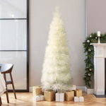 White artificial christmas tree stands in corner , surrounded by gold , white wrapped gifts,fireplace, holiday décor, greenery nearby.