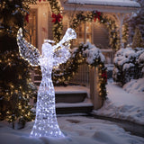 Lighted angel decor stands in snowy yard, while the house behind is adorned with festive garlands,wreaths.