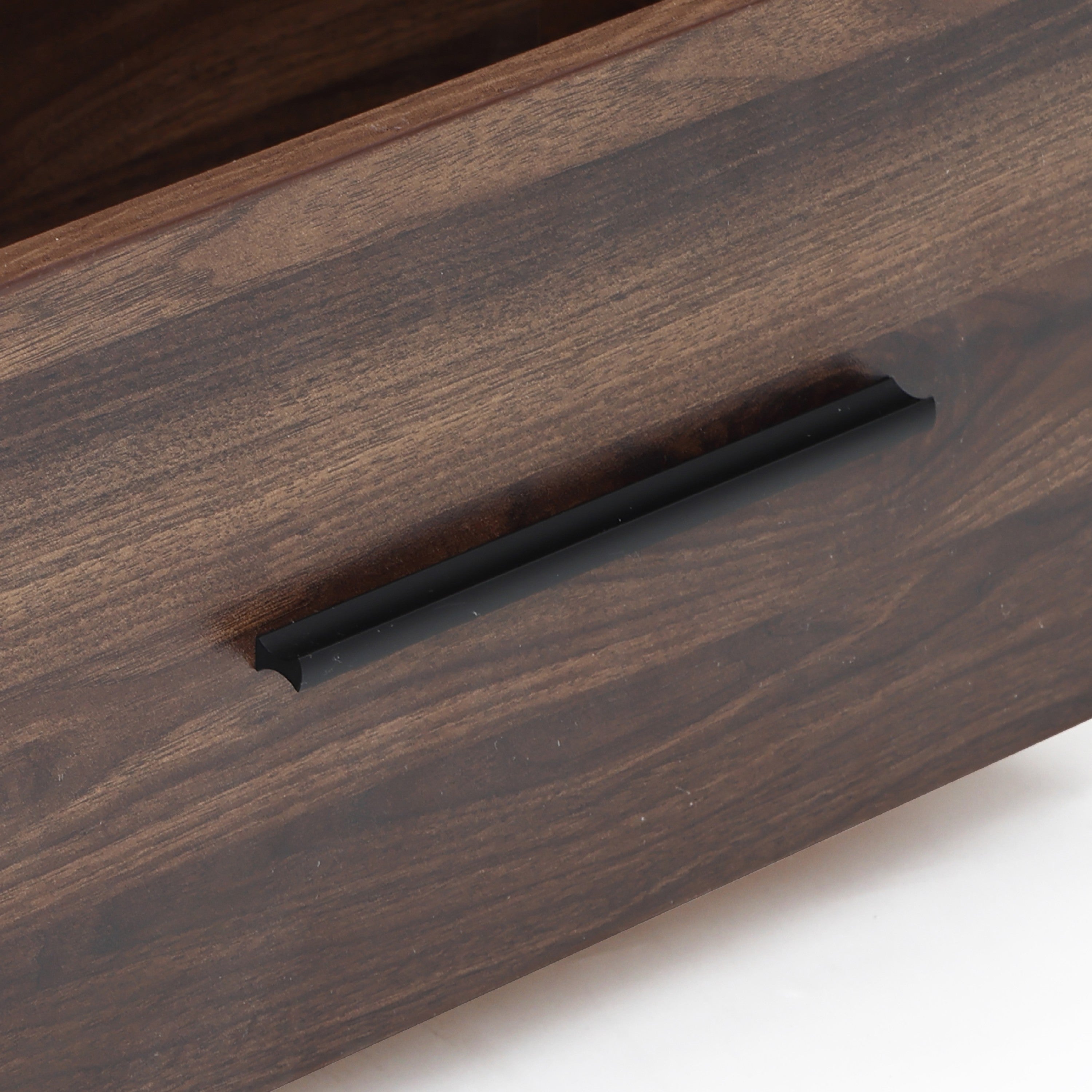 Close up of a dark wood drawer with a black horizontal handle, part of a sleek walnut TV stand entertainment console.