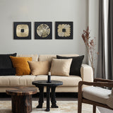Beige sofa featuring three abstract metal wall art pieces above and two wooden tables in the foreground.