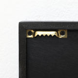 Hanger attached to the back of a black wooden frame with two screws, ideal for securely displaying abstract metal wall art or modern wall decor.