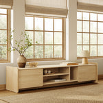 Minimalist wooden TV console cabinet placed in front of large windows with beige blinds.
