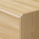 Close-up of a wooden TV console cabinet with smooth, rounded edges and a visible wood grain pattern.