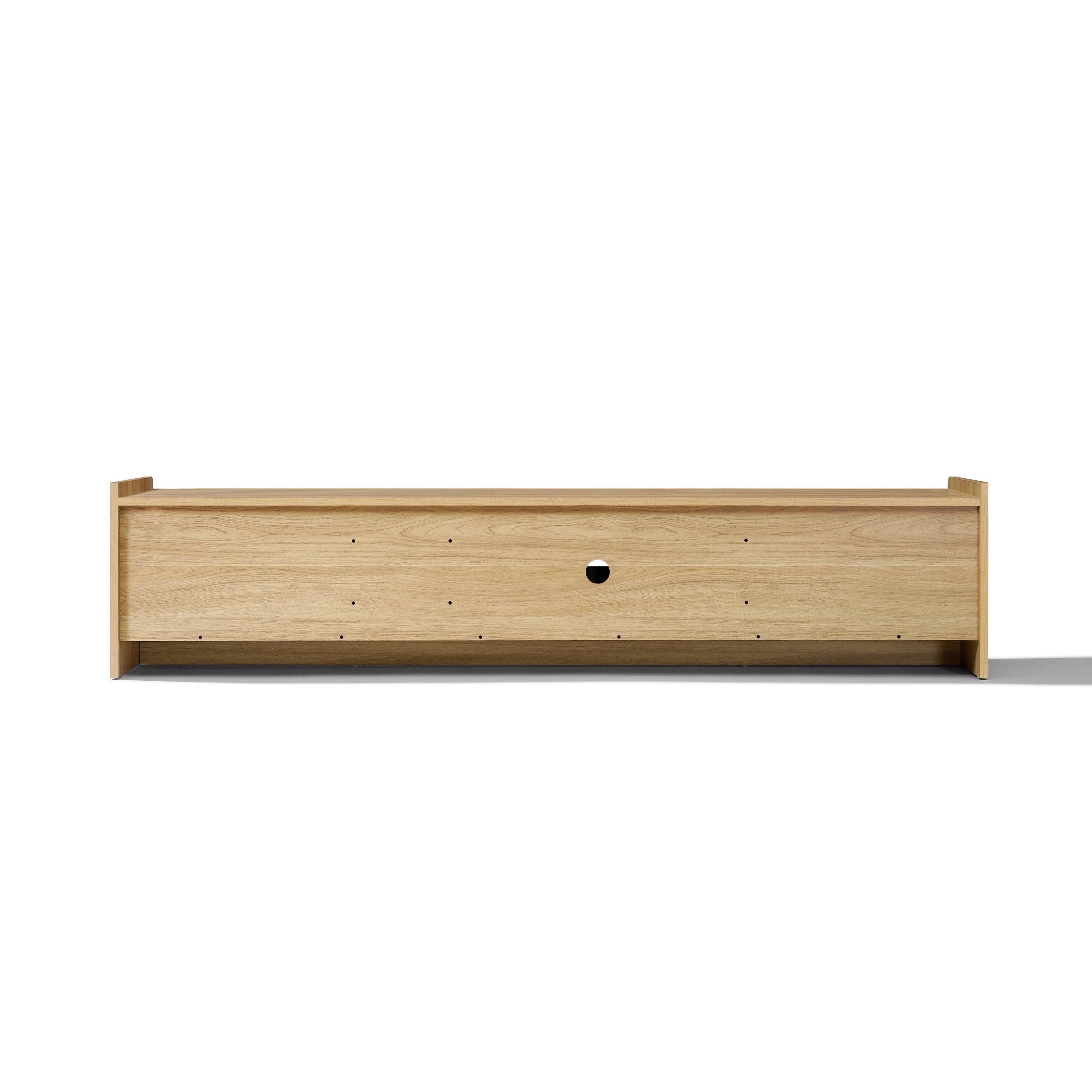 Rectangular wooden TV stand with a light wood finish, a circular cable hole in the center panel.