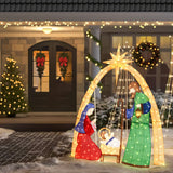 Lighted nativity scene with Mary, Joseph, baby Jesus is displayed in snowy front yard.