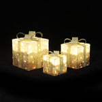 3 illuminated led Gift Boxes with gold ribbons and glitter, displayed against a black background.