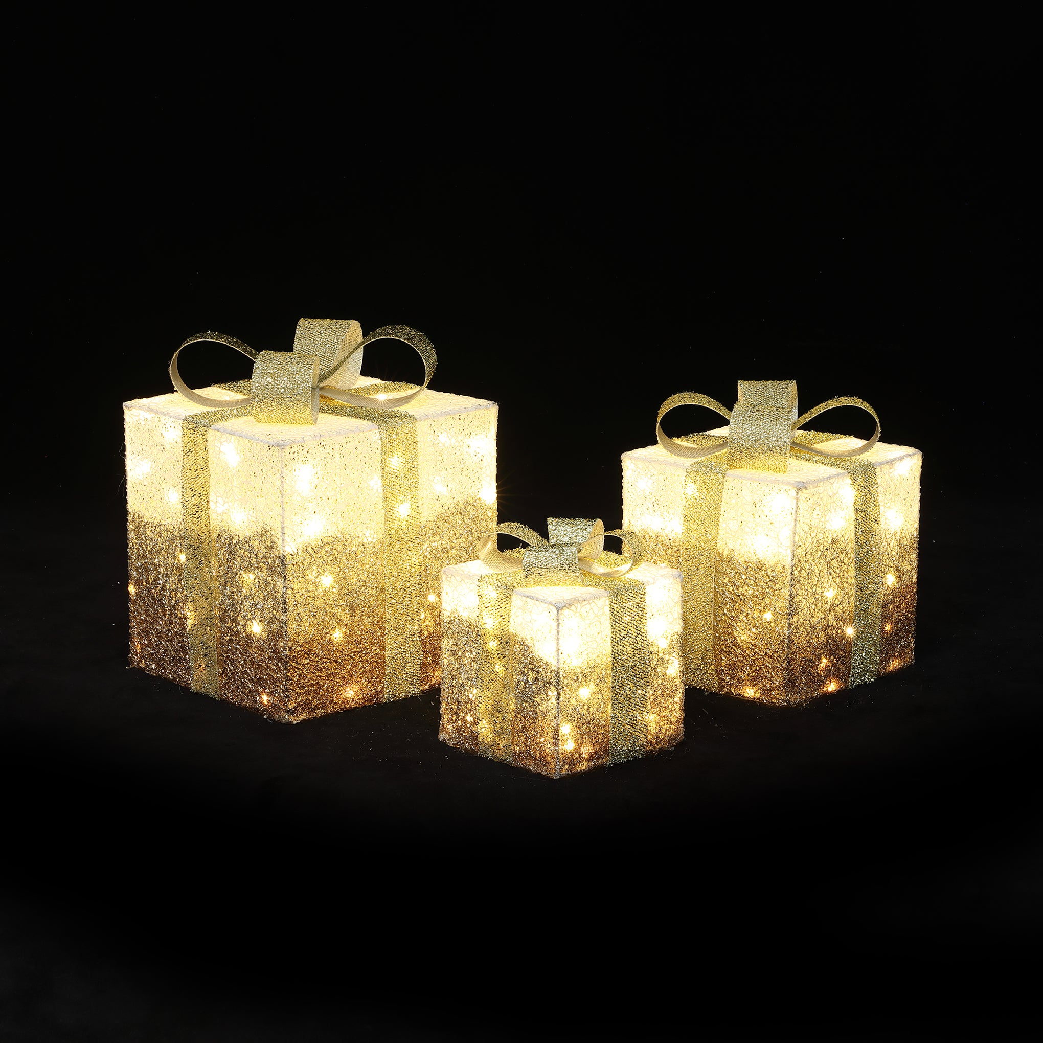 3 illuminated led Gift Boxes with gold ribbons and glitter, displayed against a black background.