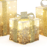 3 decor led gift boxes with gold glitter ,ribbon are illuminated from within, against a crisp white background.
