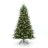 Pre-lit christmas tree with white lights stands on black metal stand against white background.